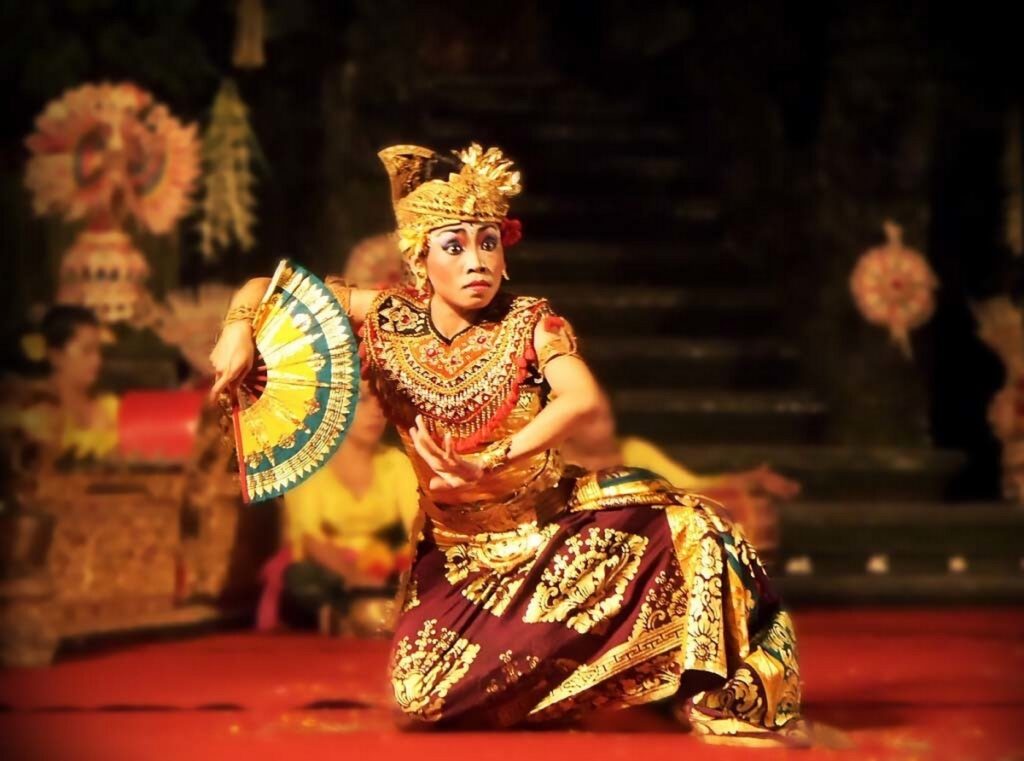 Une femme en costume traditionnel effectue une danse, exprimant la culture et les traditions balinaise