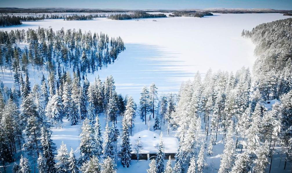 Photo d'un chalet seul au milieu du désert blanc de la Laponie